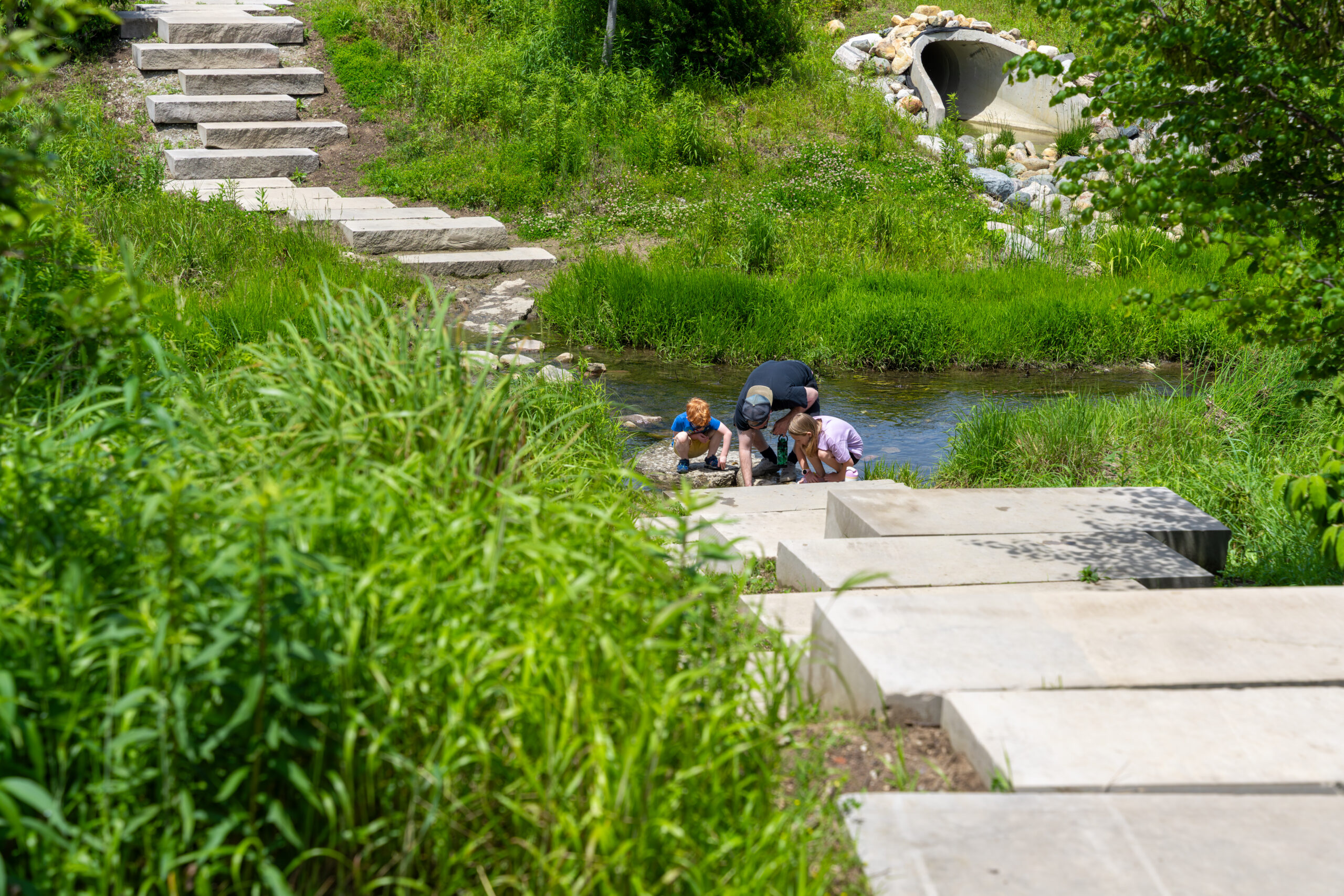 Picture of a father and two children exploring a stream in Westfield, Indiana